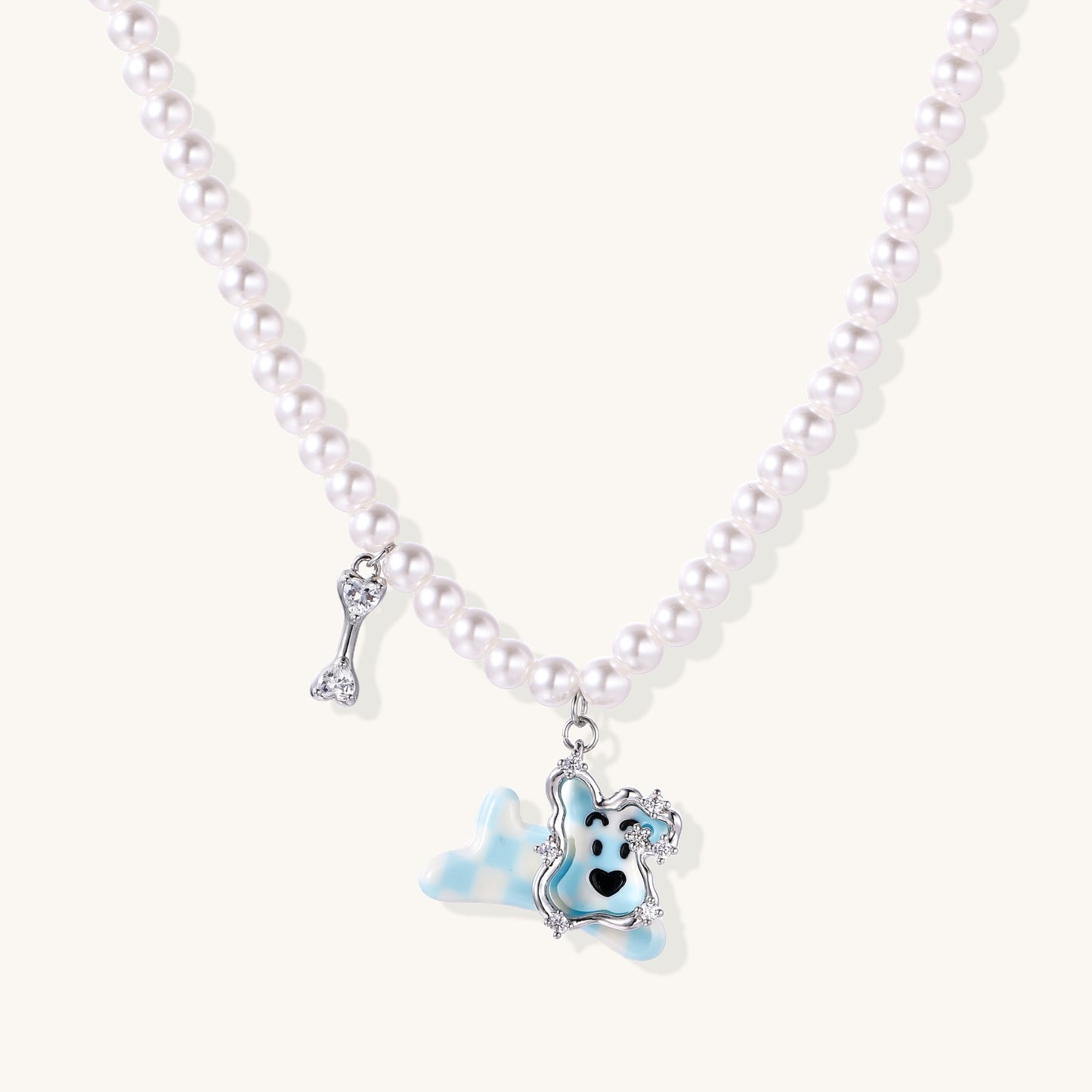 Pearl necklace with adorable blue dog pendant featuring crystal accents and bone charm on neutral background