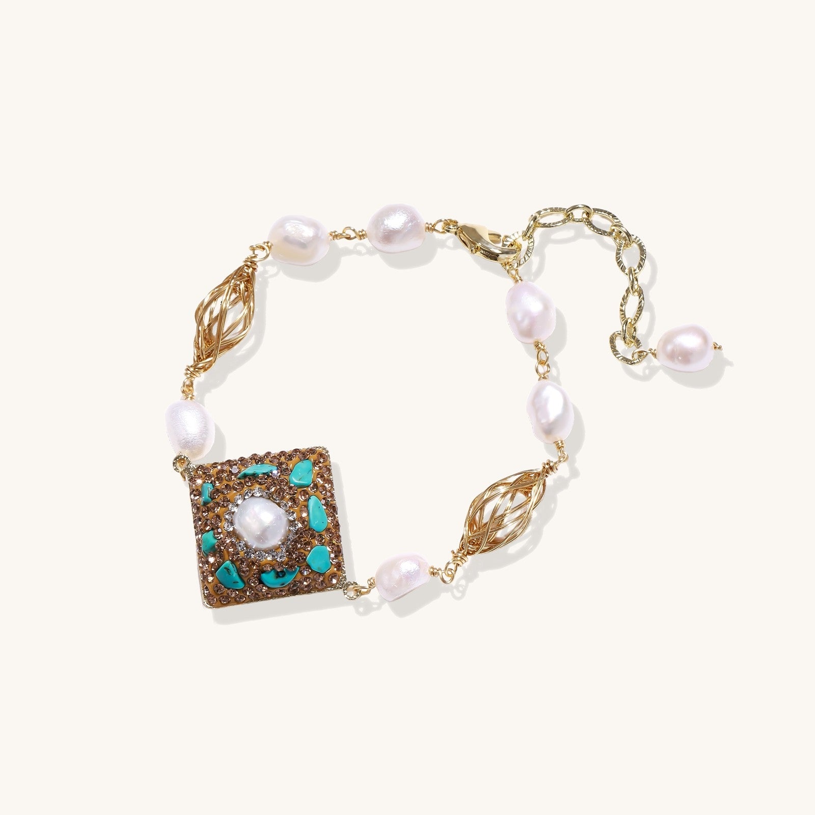 Ornate gold-plated bracelet with square turquoise and crystal centerpiece, freshwater pearls, and decorative chain links