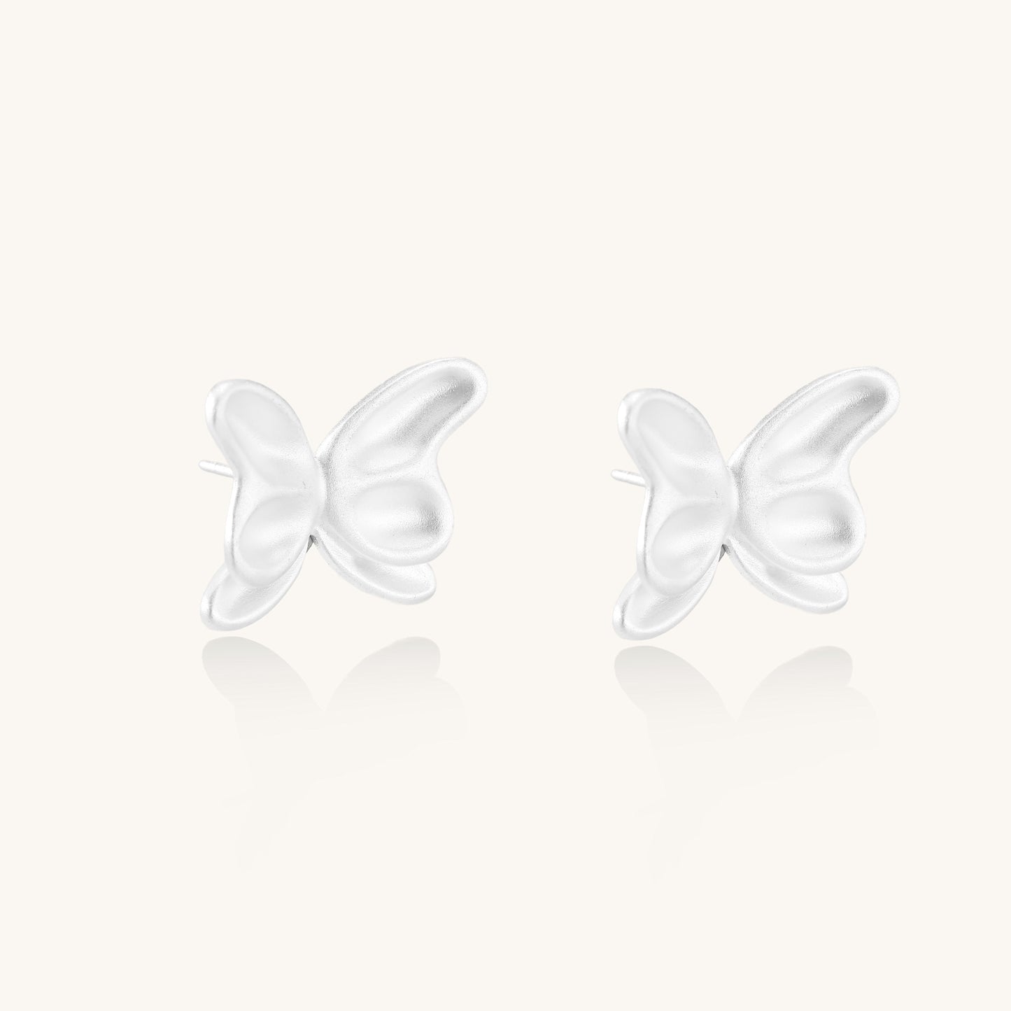 Delicate sterling silver butterfly stud earrings with intricate wing details on a neutral background.
