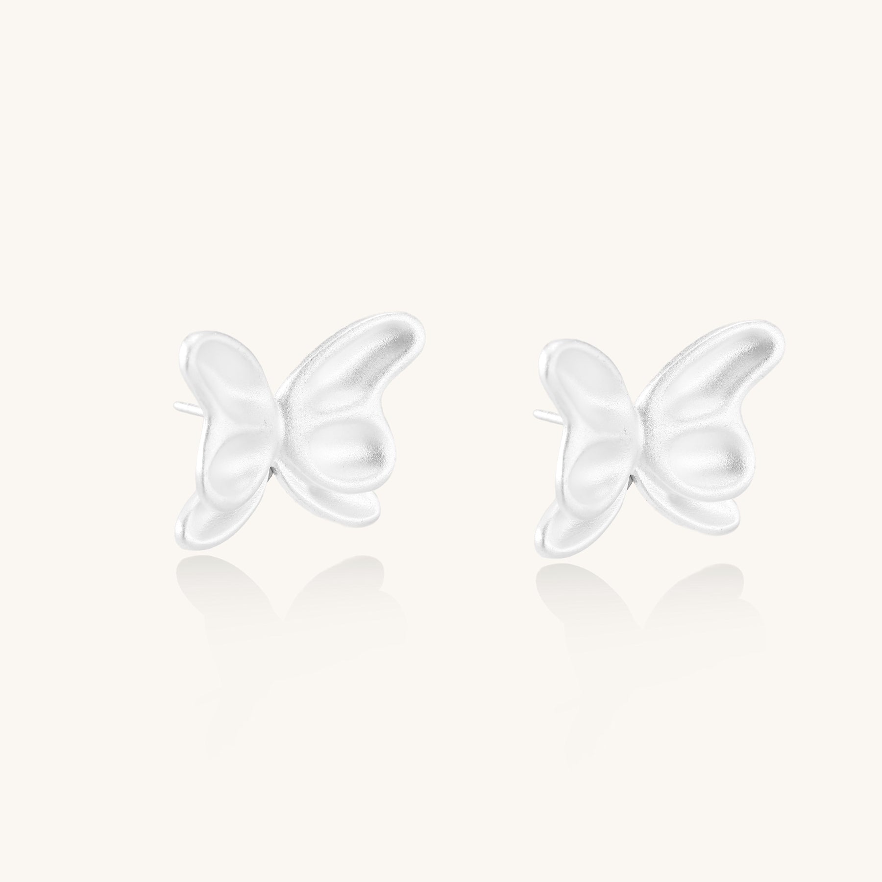 Delicate sterling silver butterfly stud earrings with intricate wing details on a neutral background.