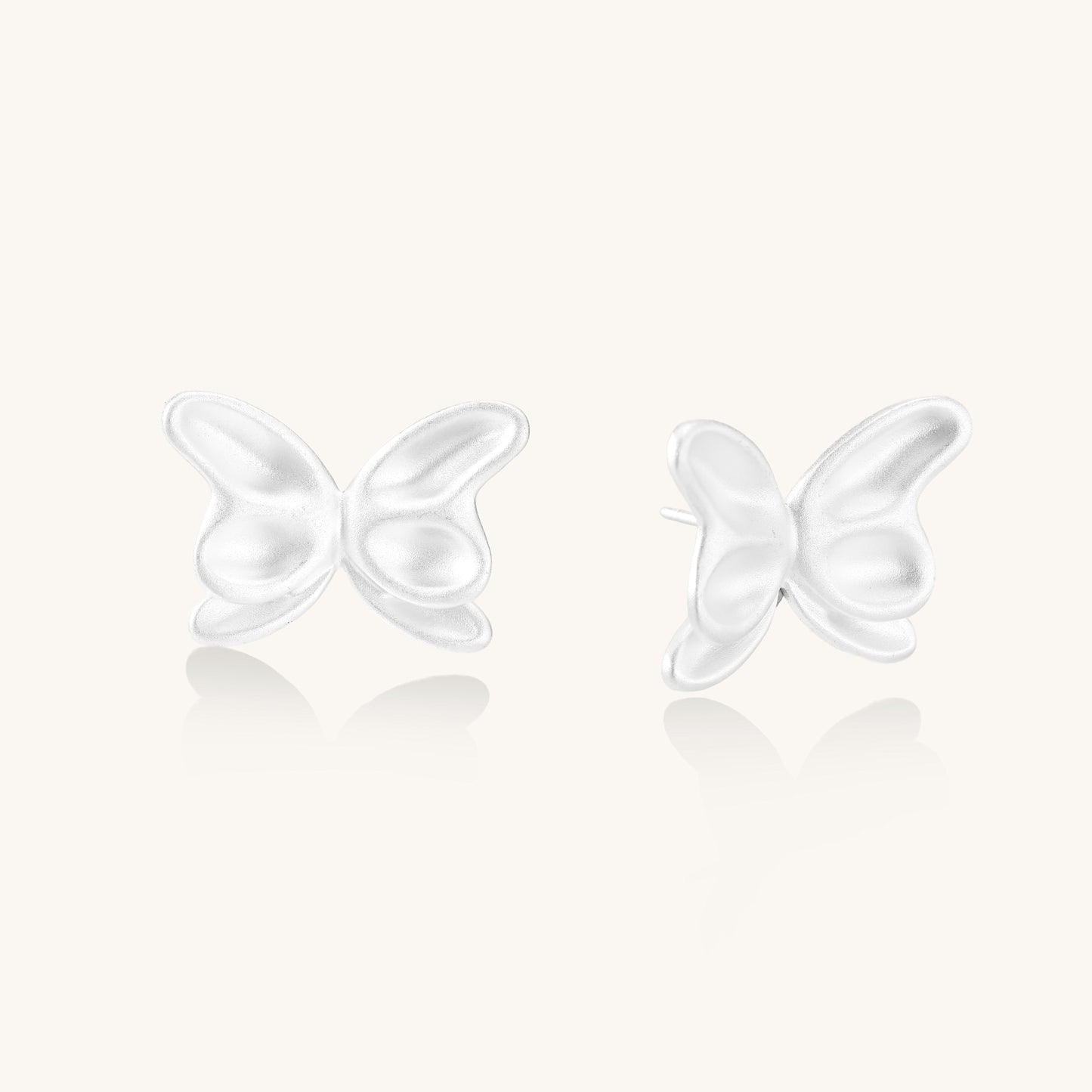 Delicate sterling silver butterfly stud earrings with intricate wing details on a neutral background.