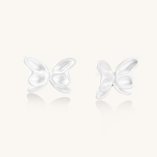 Delicate sterling silver butterfly stud earrings with intricate wing details on a neutral background.