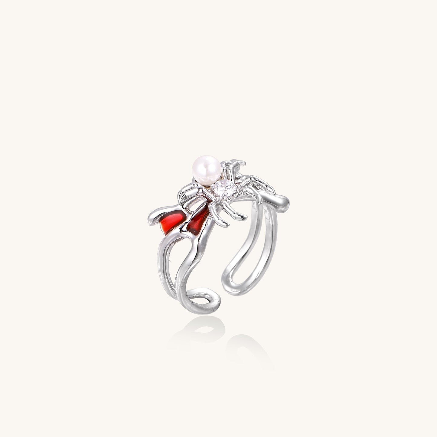 Gold-plated adjustable ring featuring spider design with white pearl, red enamel accents, and central zirconia stone
