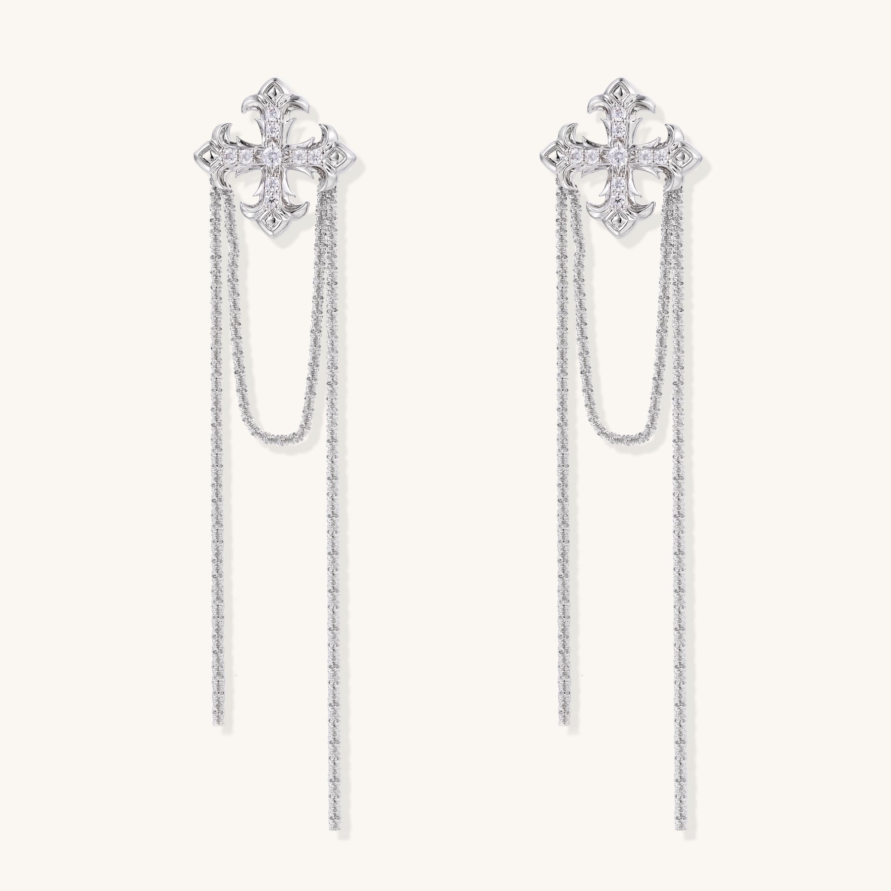Ornate gold-plated cross earrings with zirconia crystals and flowing chain details on white background