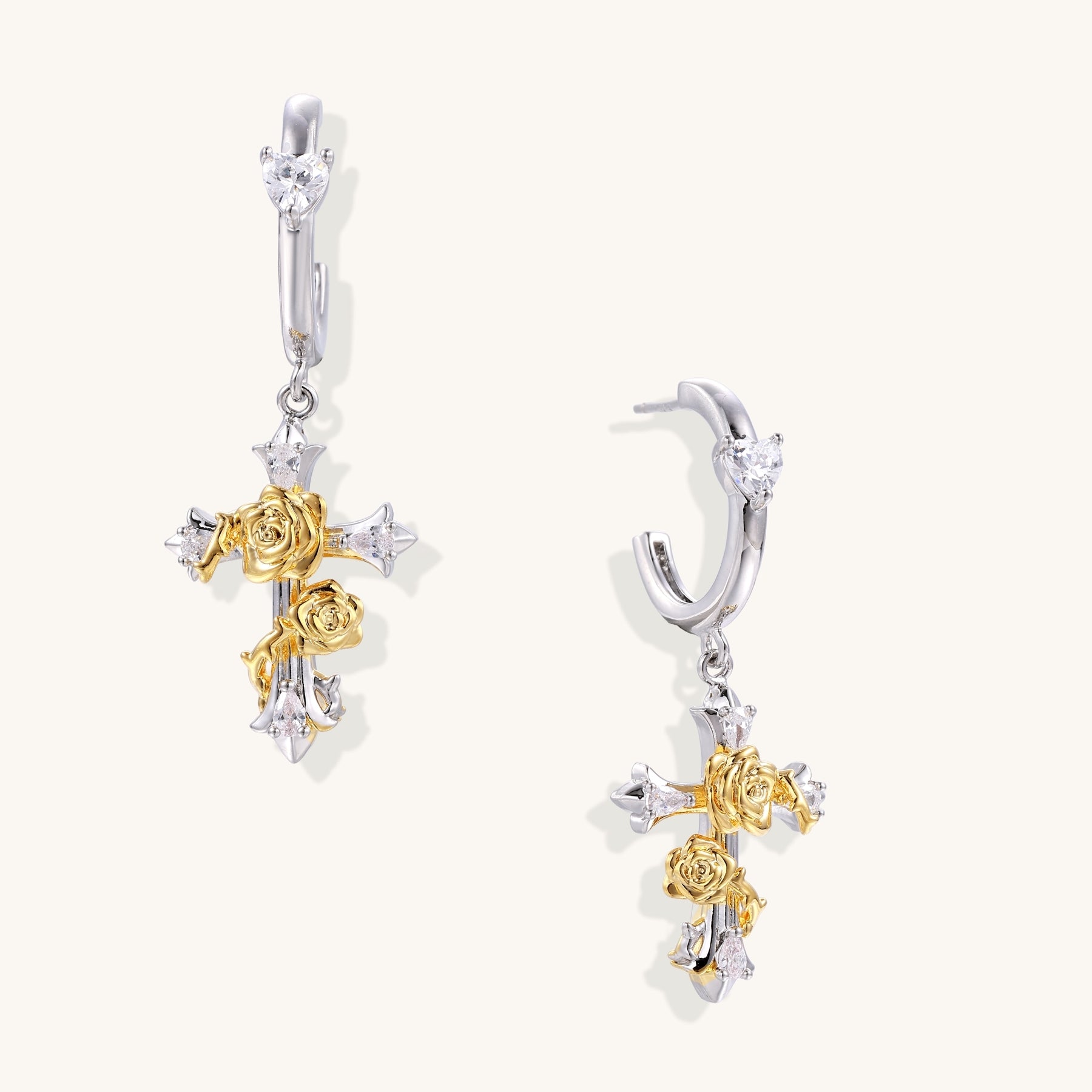 Ornate cross-shaped dangle earrings with gold roses and sparkling zirconia stars on silver-toned base with hoop closures.