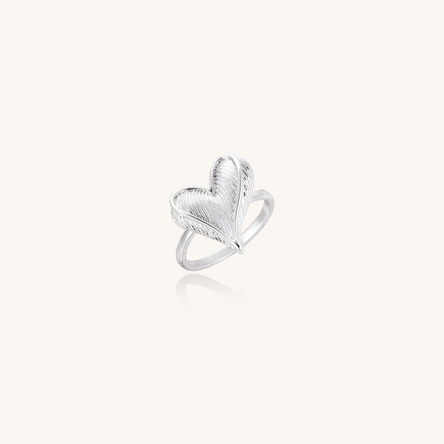 18K gold plated brass ring with intricate feather design forming a heart shape on white background.