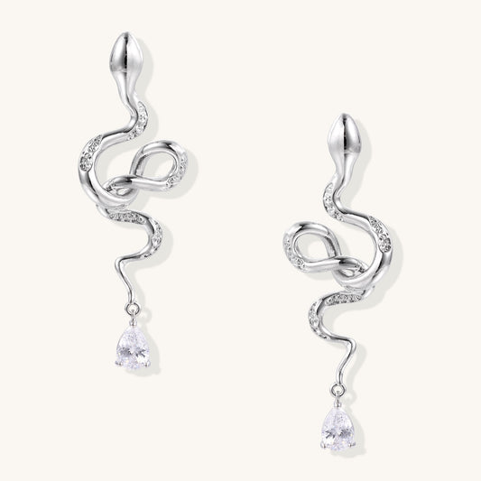 Coiled gold-plated snake earrings with zirconia stones and teardrop crystal dangles against white background.