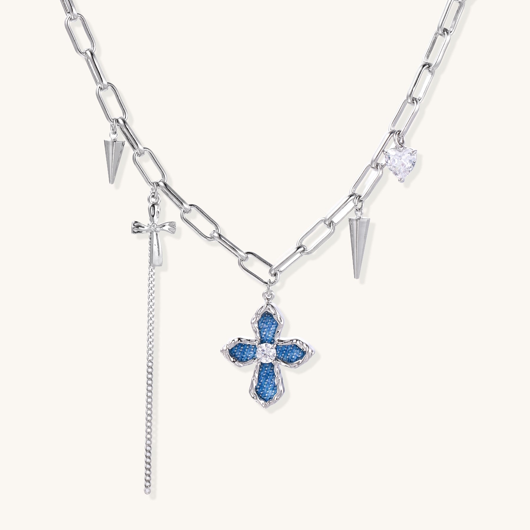 18K gold plated brass chain necklace featuring blue cross pendant with zirconia center stone and spike charms on white background.