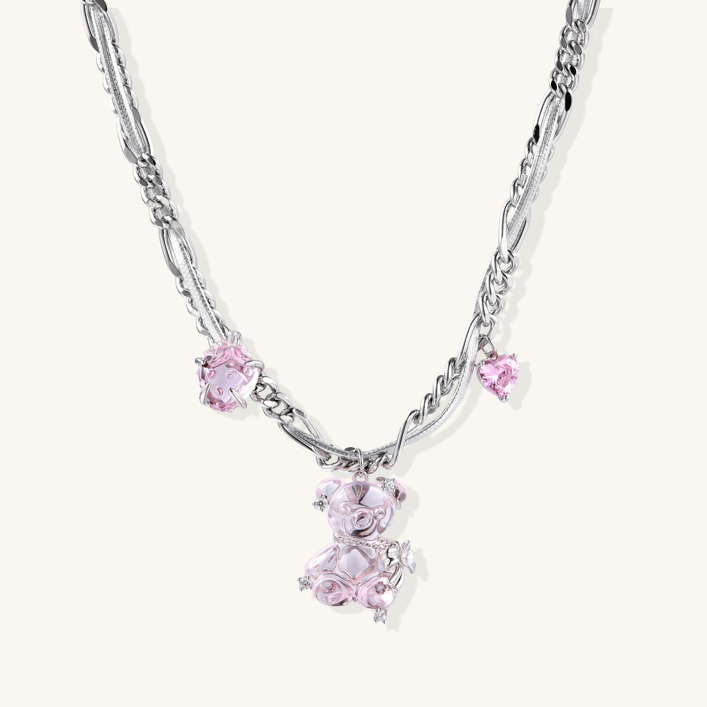 Adjustable gold-plated brass chain necklace with pink zirconia crystals and mixed link patterns on white background.