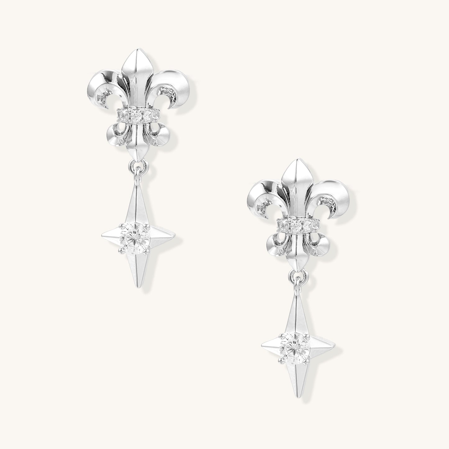 Gold-plated fleur-de-lis earrings with zirconia crystals and dangling star-shaped drops on white background.