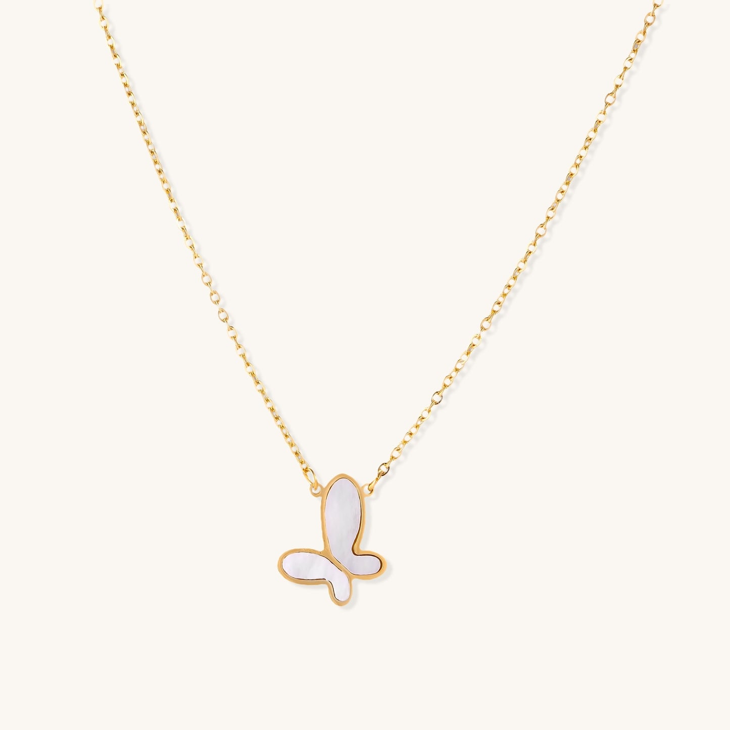 Delicate gold butterfly necklace with white mother of pearl wings on fine chain, displayed on neutral background.